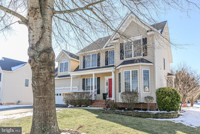 view of front facade with a garage, a front yard, and a porch