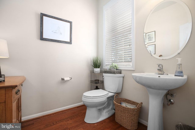 bathroom with hardwood / wood-style flooring and toilet