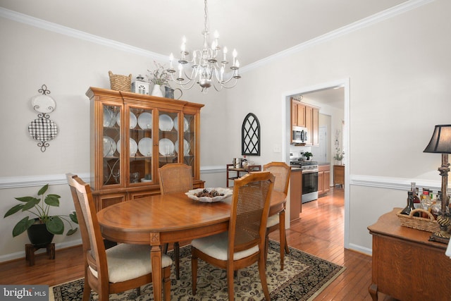 dining area featuring ornamental molding, a chandelier, and light hardwood / wood-style floors