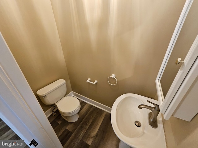 bathroom with toilet, wood-type flooring, and sink