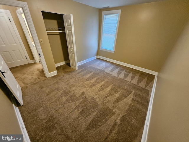 unfurnished bedroom featuring light colored carpet and a closet