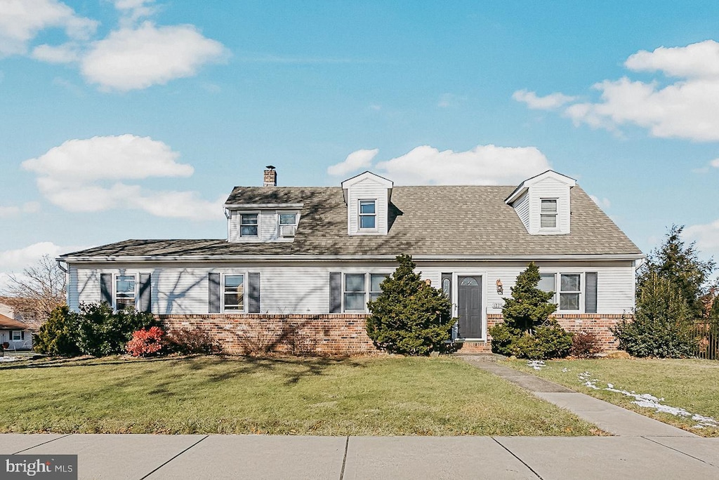 new england style home featuring a front lawn