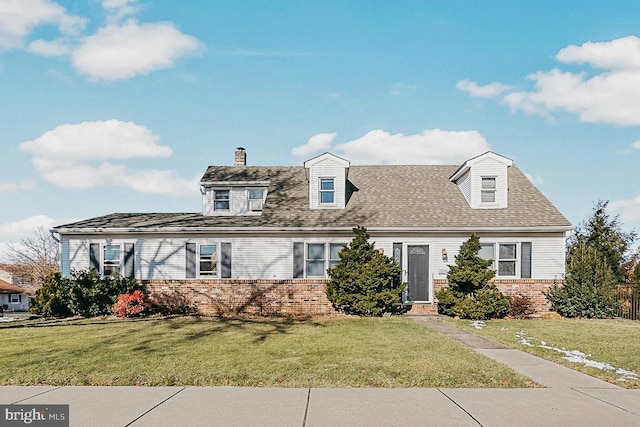 new england style home featuring a front lawn