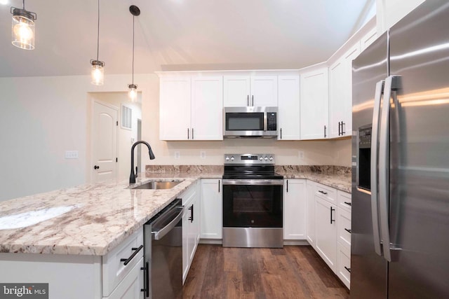 kitchen with dark wood finished floors, appliances with stainless steel finishes, a peninsula, white cabinetry, and a sink