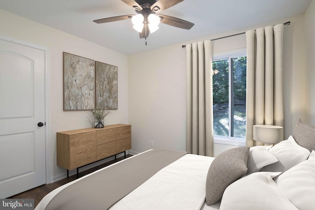 bedroom with multiple windows, ceiling fan, and dark wood-type flooring