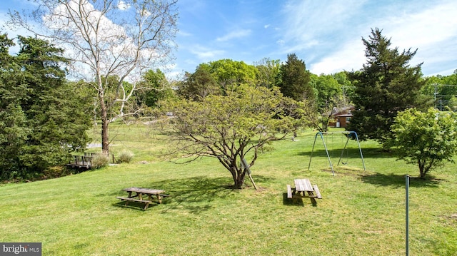 view of community featuring a playground and a lawn