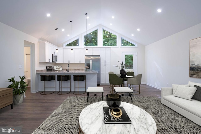 living room with dark wood-type flooring, recessed lighting, and high vaulted ceiling