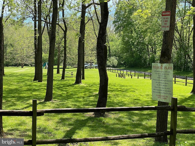 view of property's community with a yard and fence