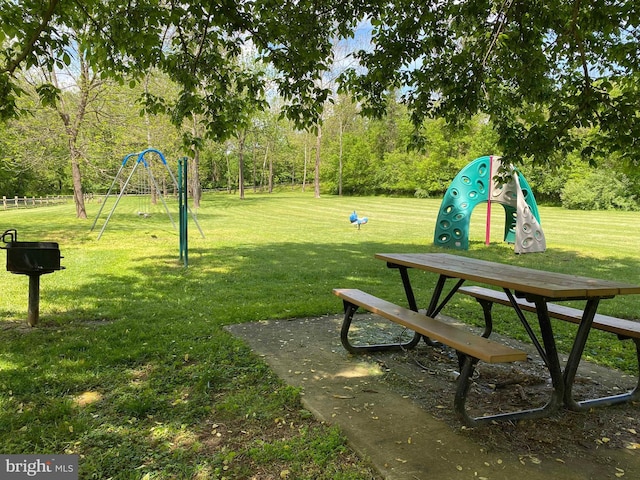 view of property's community with playground community and a lawn