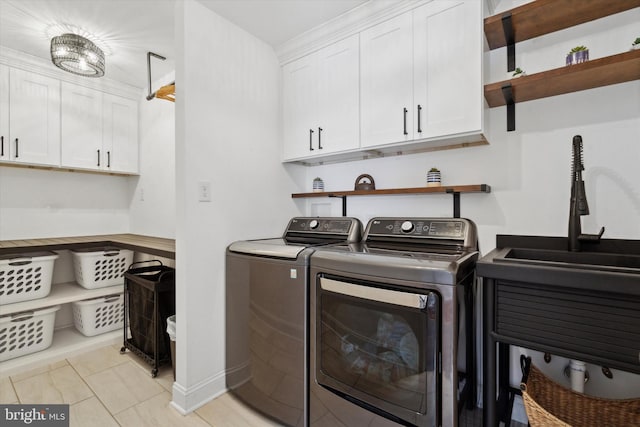 laundry room featuring sink, cabinets, washer and clothes dryer, and light tile patterned floors