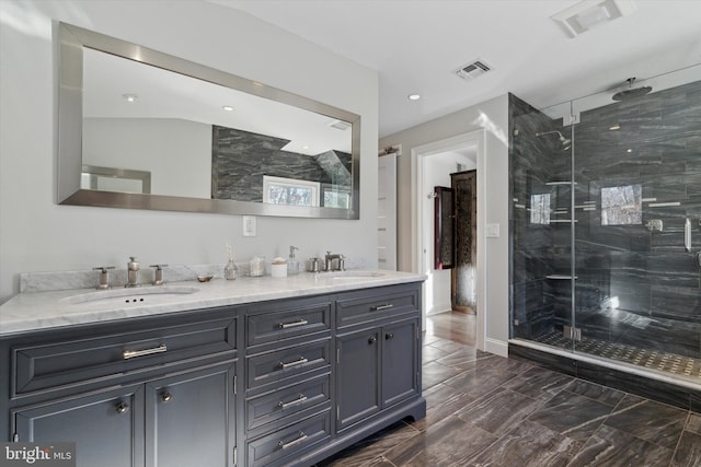 bathroom with a shower with door and vanity