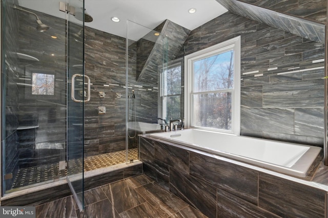 bathroom featuring tile walls and shower with separate bathtub