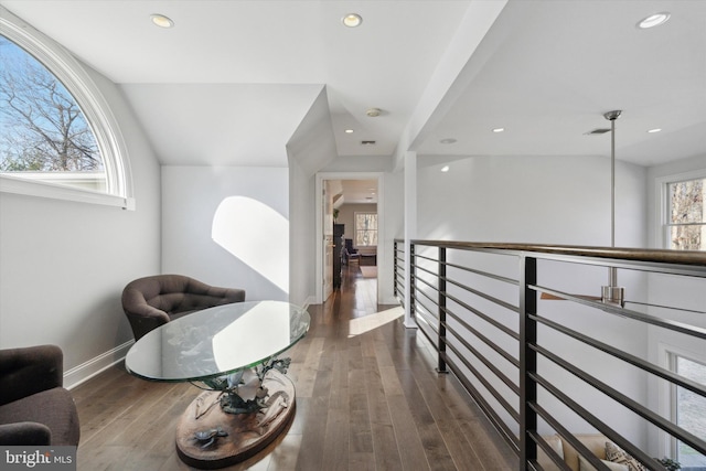 corridor with dark hardwood / wood-style floors and plenty of natural light