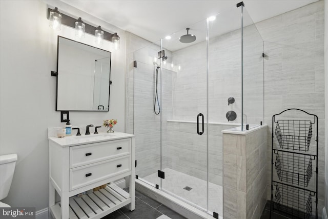 bathroom with vanity, toilet, walk in shower, and tile patterned floors