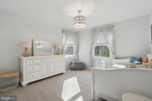 carpeted bedroom featuring a chandelier