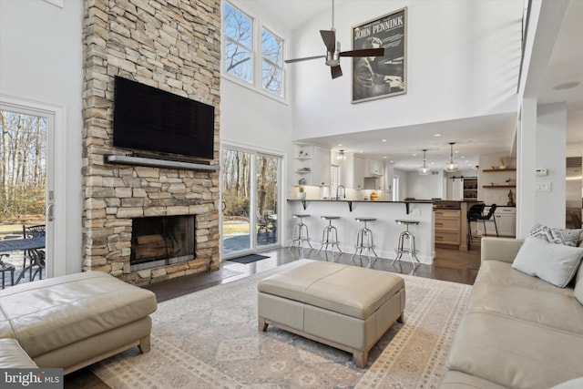 living room with a high ceiling, a wealth of natural light, and a fireplace