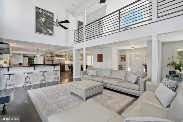 living room featuring a high ceiling, ceiling fan, hardwood / wood-style floors, and a wealth of natural light