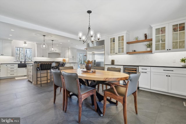 dining space featuring beverage cooler and a notable chandelier