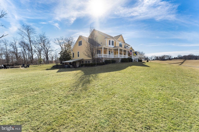 view of side of property with a yard and covered porch