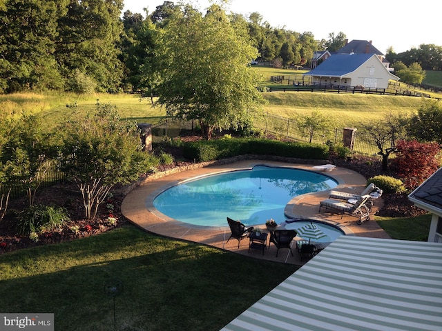 view of pool featuring a patio, a fenced in pool, fence, a diving board, and a lawn