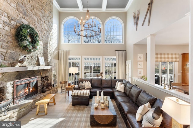 living area featuring beamed ceiling, a towering ceiling, a fireplace, and crown molding