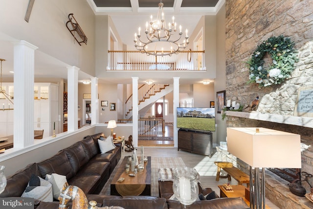 living area with stairway, coffered ceiling, ornate columns, and wood finished floors