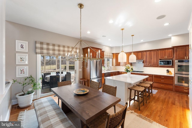 dining room with light wood finished floors, recessed lighting, and an inviting chandelier