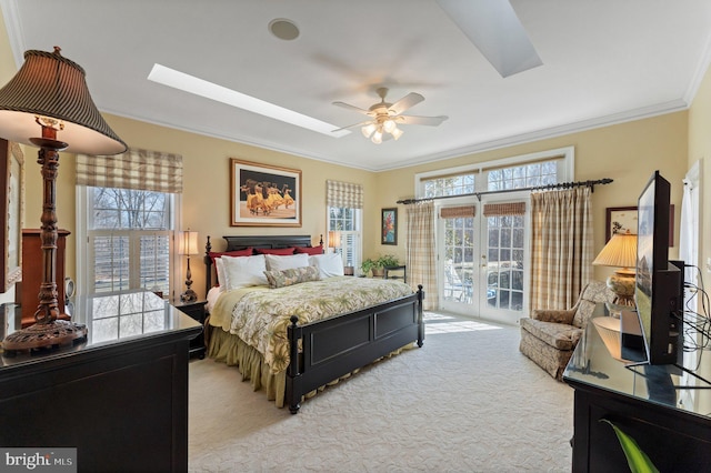 bedroom with light colored carpet, a skylight, ornamental molding, and access to outside