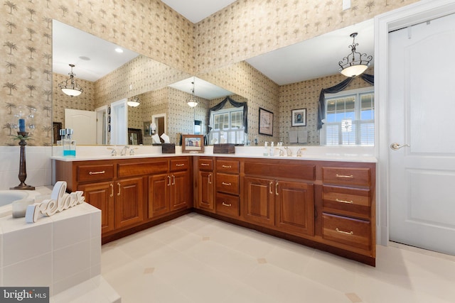 bathroom featuring wallpapered walls, double vanity, a bathing tub, and a sink