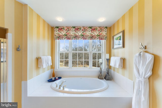 full bath featuring a garden tub and wallpapered walls