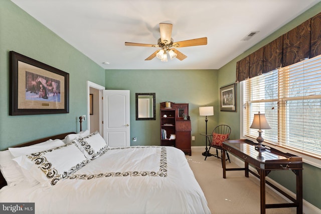 bedroom with baseboards, visible vents, and light carpet