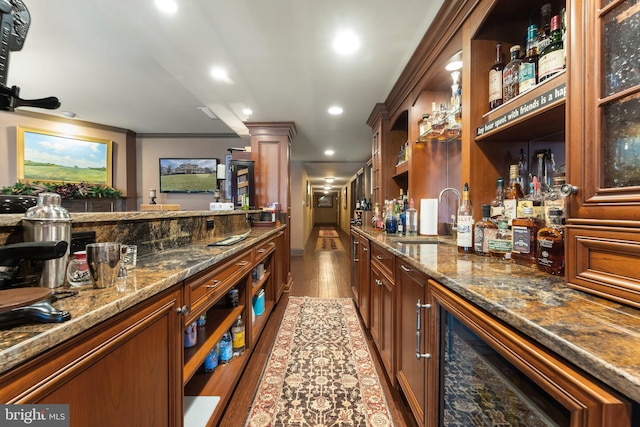 bar with wood finished floors, recessed lighting, a sink, indoor wet bar, and crown molding