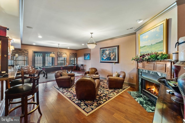 living area with a high end fireplace, visible vents, crown molding, wood finished floors, and billiards