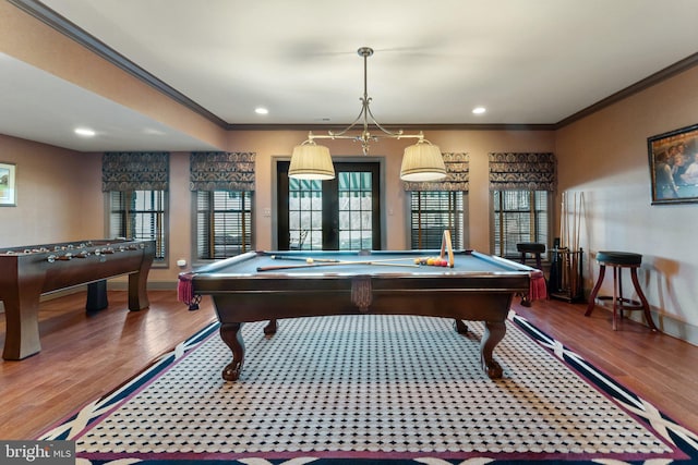 recreation room with recessed lighting, wood finished floors, baseboards, and ornamental molding