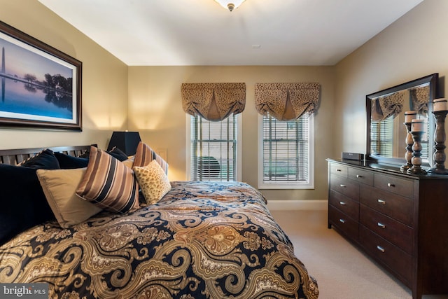 bedroom featuring light colored carpet and baseboards