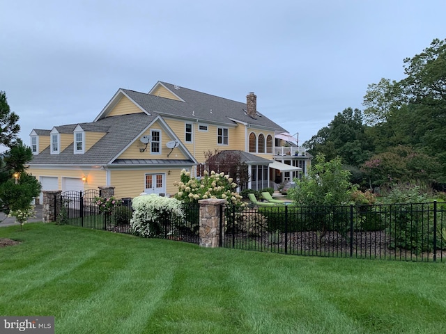 back of house with a lawn, a chimney, and fence