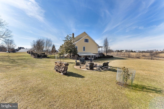 view of yard featuring a patio, a fire pit, and fence