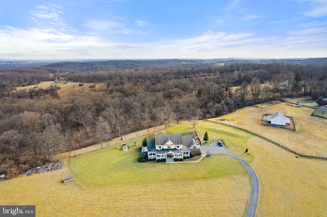 drone / aerial view featuring a rural view and a wooded view