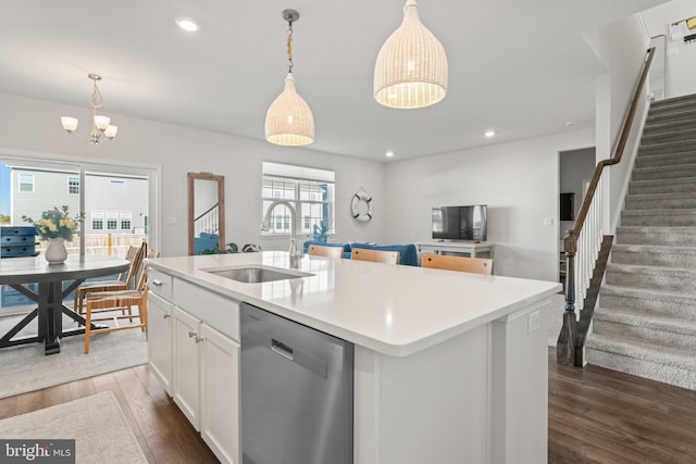 kitchen with a kitchen island with sink, pendant lighting, stainless steel dishwasher, and sink