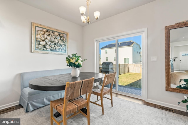 dining space with a notable chandelier and light hardwood / wood-style flooring