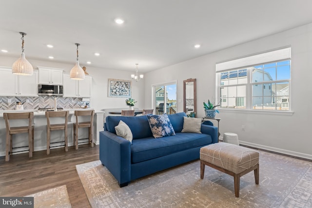 living room with an inviting chandelier and dark hardwood / wood-style floors