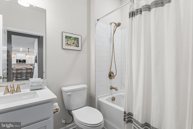 full bathroom with shower / bath combo, vanity, and toilet