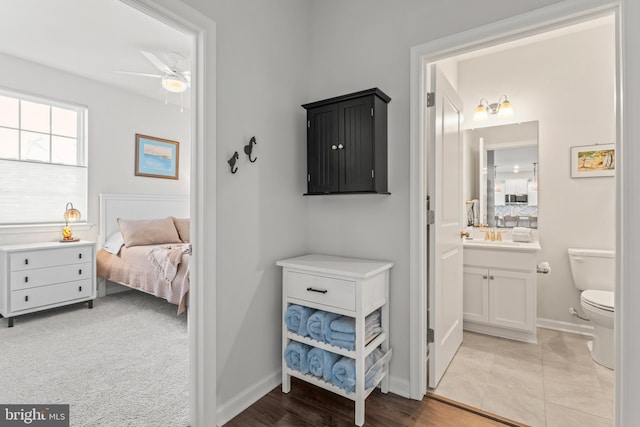 interior space featuring toilet, vanity, and ceiling fan