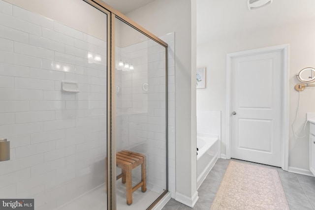 bathroom featuring tile patterned flooring, shower with separate bathtub, and vanity