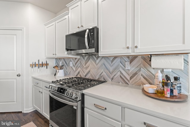 kitchen with stainless steel appliances, dark hardwood / wood-style floors, backsplash, and white cabinetry