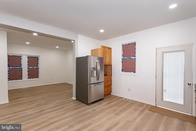 kitchen featuring light wood-type flooring, light brown cabinetry, and stainless steel refrigerator with ice dispenser