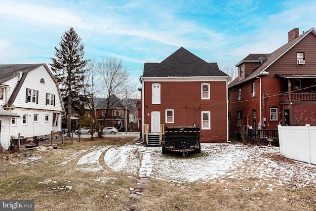 view of snow covered rear of property