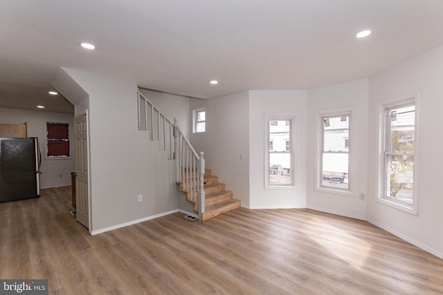 unfurnished living room with light hardwood / wood-style floors and plenty of natural light