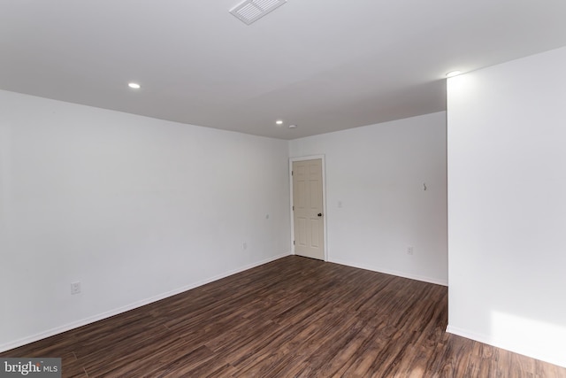 unfurnished room with dark wood-type flooring