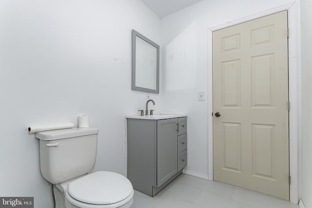 bathroom featuring toilet, tile patterned flooring, and vanity